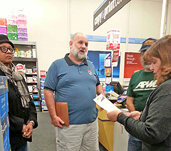 APWU members Venus Abaoag-Smith and Roy Gernhardt look on as Local President LeRoy Moyer discusses the issue with Assistant Manager Mindy Press.