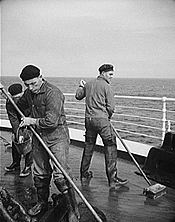 Sailors swab a deck (circa 1930).