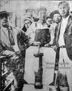 Miners display an unexploded bomb that was dropped on them by a coal company plane.