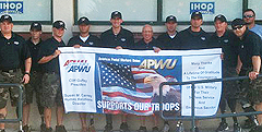 The Wounded Warriors display an APWU banner at a tribute breakfast hosted for the team by the Oklahoma City Area Local on July 23. The team was in town to play in an exhibition game with the USA Softball Men’s Slow Pitch National Team during the 2011World Cup of Softball.