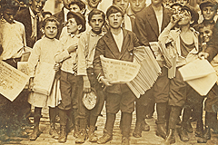 Newsboys (and newsgirl) prepare to sell papers near the New York World building, July 1910.