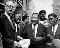A U.S. marshal serves Martin Luther King Jr. with a temporary restraining order barring a march in Memphis without court approval on April 3, 1968. With King, center, are top aides (left to right) Rev. Ralph Abernathy, Andrew Young, James Orange and Bernard Lee.
