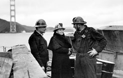 Perkins talks with workers during construction of the San Franciscoside tower of the Golden Gate Bridge.