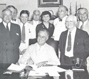 Perkins and members of Congress watch as President Roosevelt signs the Social Security Act into law in late 1935. (Photo: Wirtz Library, U.S. Department of Labor)