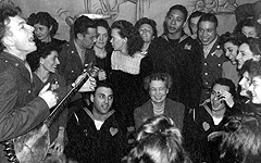 Eleanor Roosevelt is entertained by folk singerPete Seeger at a party held by United Federal Workers of America, 1944.