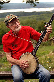 Seeger near his home on the Hudson River. Stenciled on his banjo: “This machine surrounds hate and forces it to surrender.”