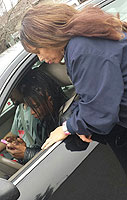 APWU member Tracy Morris Blakely helps friends sign the Stop Staples petition using a mobile phone.