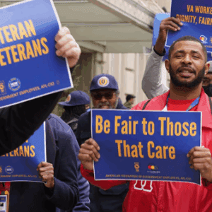 AFGE members rally holding signs taht say Be Fair to Those that Care and Proud Veteran Serving Veterans
