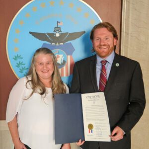 A photo of Columbus Auxiliary Treasurer Angela Lyshe with President Pro Tempore Rob Dorans of the Columbus City Council holding up the signed proclamation