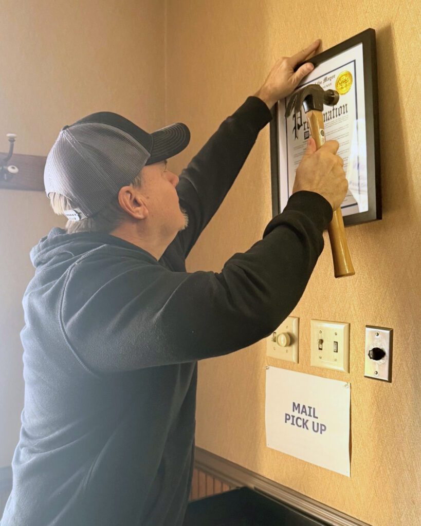 A photo of the local hanging the signed proclamation in the union hall lobby